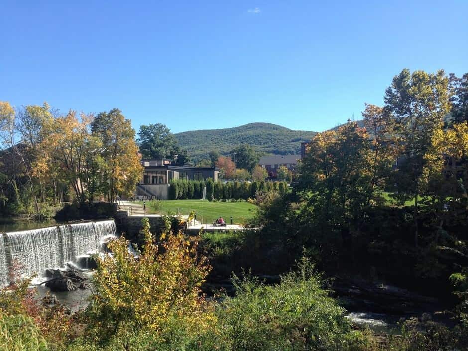 A waterfall and trees with a building and gardens in Beacon New York, a romantic place in Upstate NY