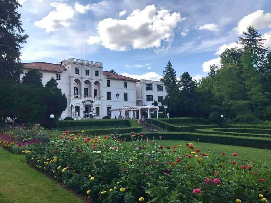 Manicured gardens and flowers with a grand white hotel, Geneva on the Lake, perfect for romantic getaways in upstate New York