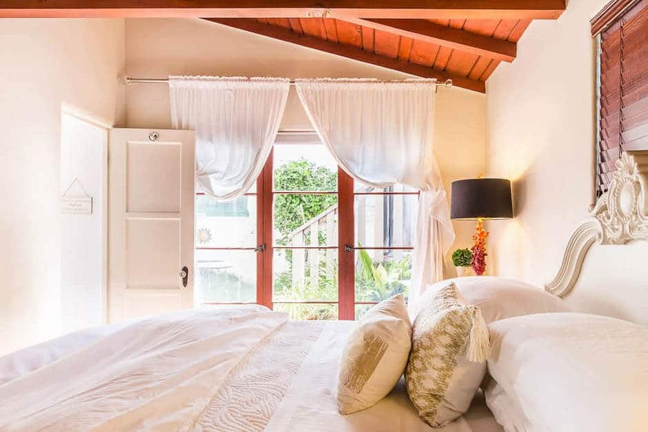 Brightly lit bedroom with wooden beam ceiling