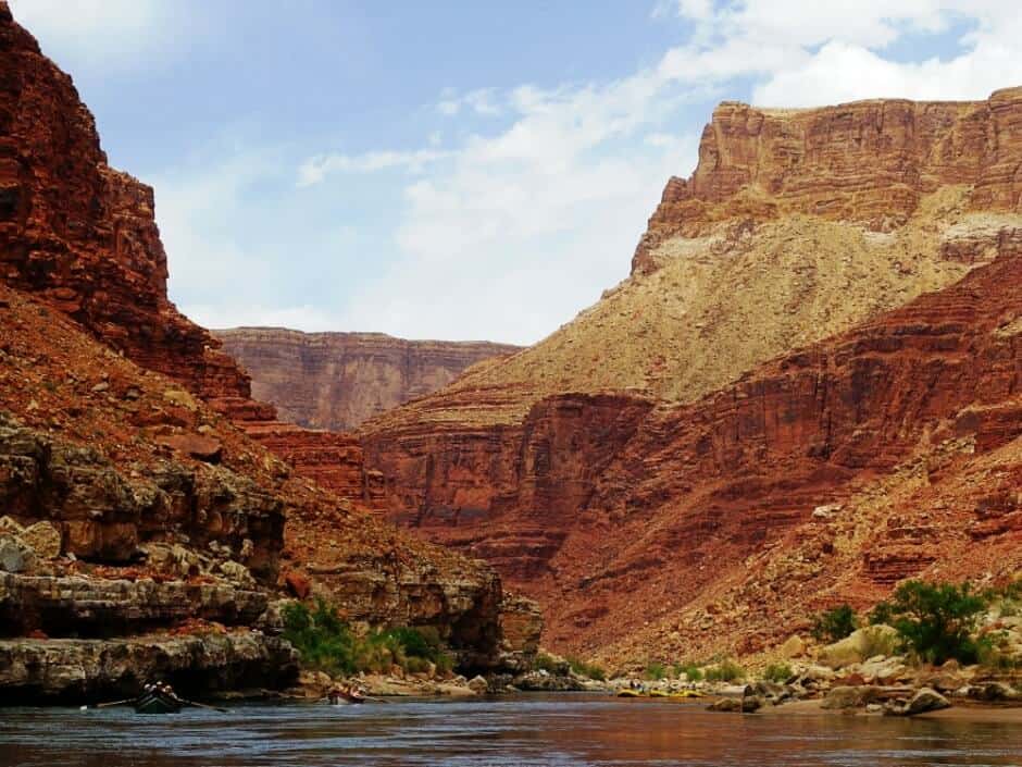 Vibrant red rock formations tower over kayakers in the river far below in Grand Canyon National Park, Arizona, possibly the best national park in the USA