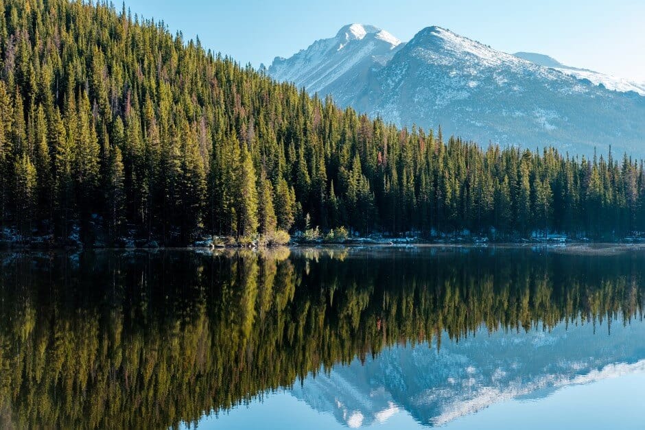 Trees and snowcapped mountains are mirrored on the surface of Bear Lake in the Rocky Mountain National Park, Colorado, parks west U.S.